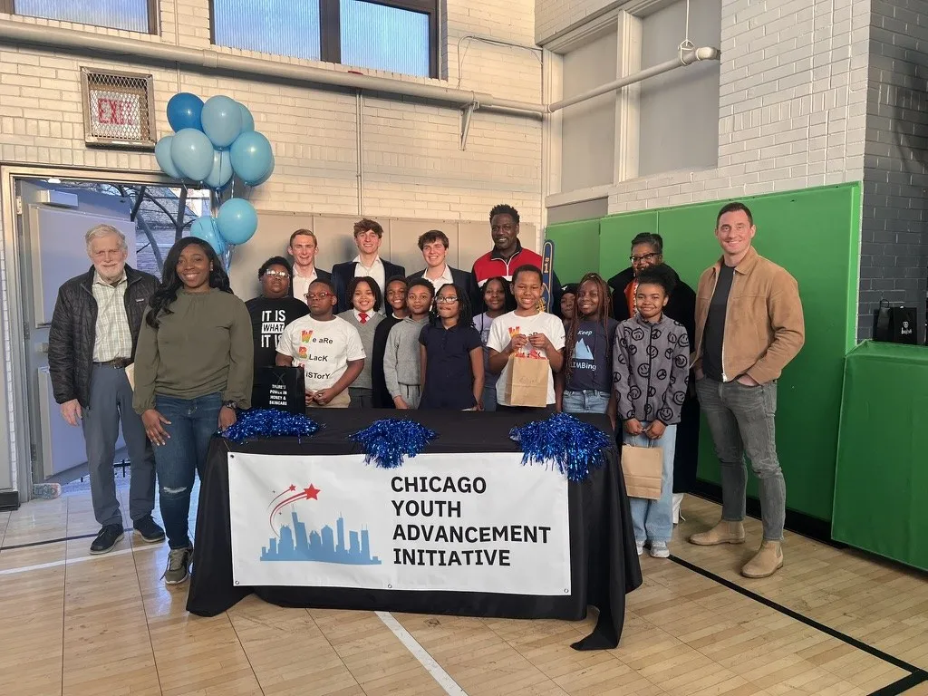 CYAI students, volunteers, and partners gathered behind the Chicago Youth Advancement Initiative banner